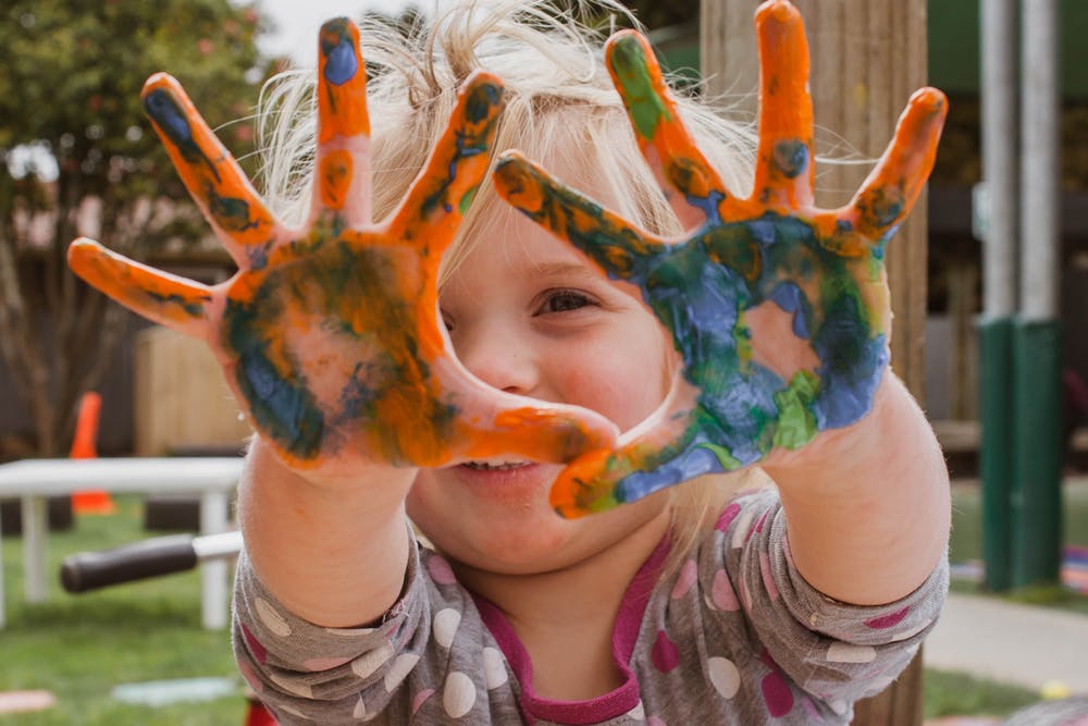 kid with paint in her hands